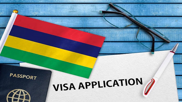 un drapeau, un stylo, un passeport, des lunettes, un papier avec l'écriture "visa application" sur une table - administration mauricienne - activsolutions