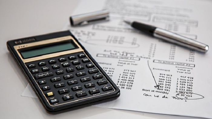 une calculatrice, une feuille de calcul et un stylo - gestionnaire de paie - Activ Solutions