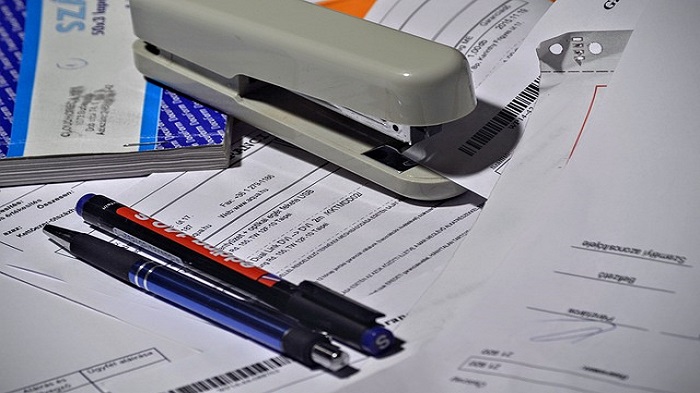 une agrafeuse et des stylos sur des documents - externalisation de services administratifs - activsolutions