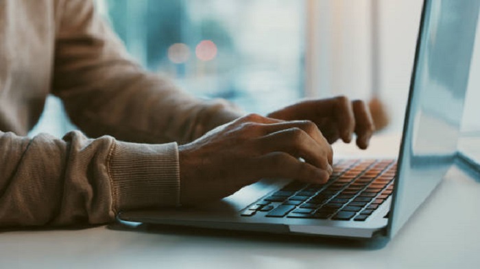 une main tapant sur un clavier de laptop - créer une société offshore en ligne - activsolution