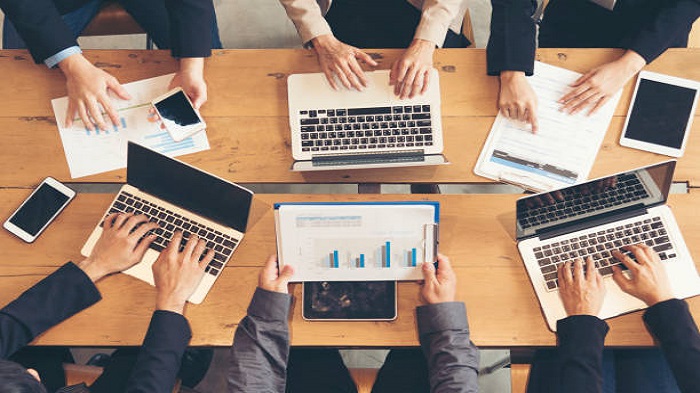 des personnes travaillant autour d'une table avec des laptops chacun - pépinière d'entreprise - Activ Solution 