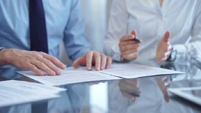 deux hommes d'affaires discutant devant un contrat - externaliser ses services - Activ Solution